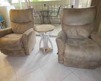 Two matching faux suede swivel, rocker recliners and octagonal end table.