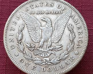 Many silver dollars and other coins and currency, including this 1878-CC.