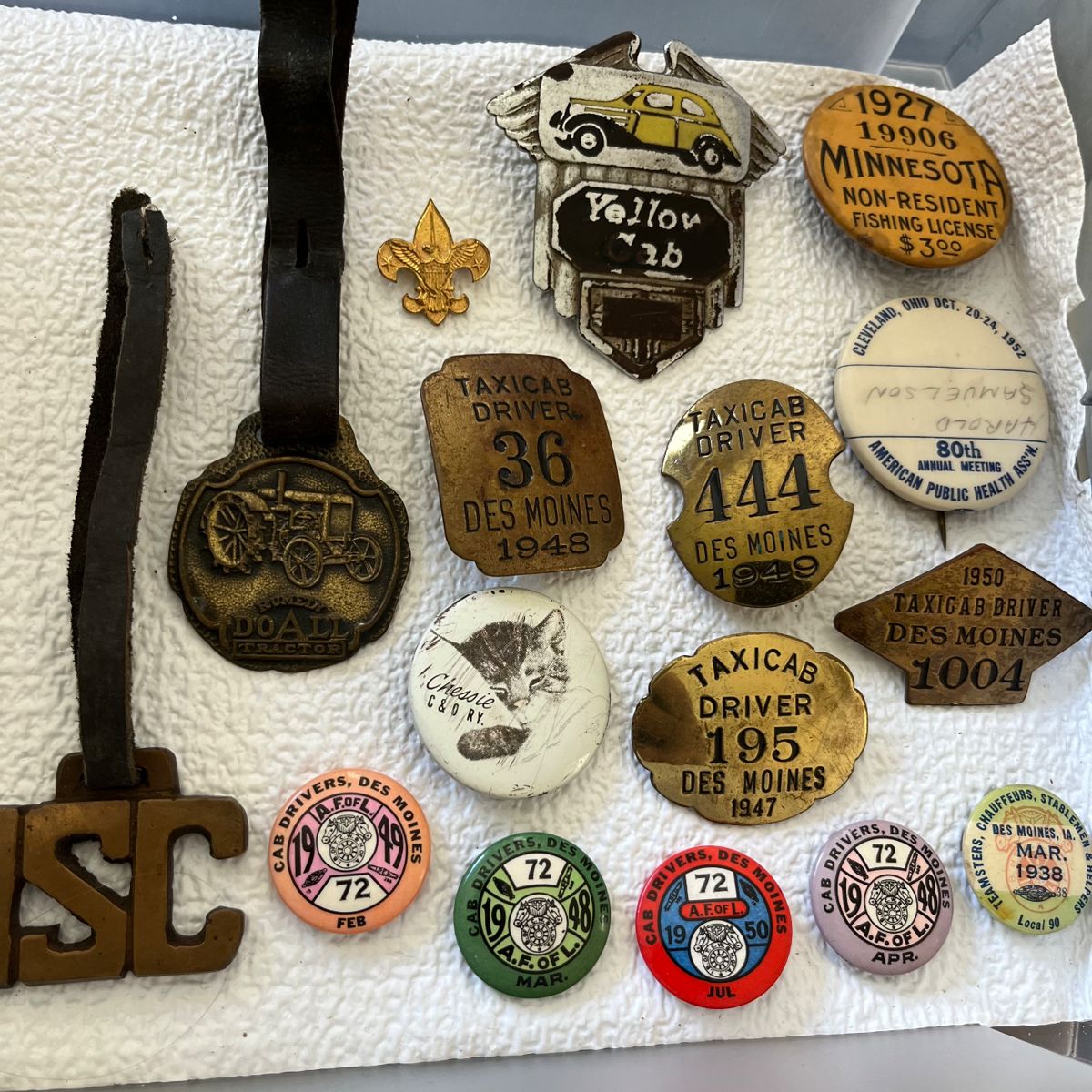 Vintage taxicab driver badges/pins (Des Moines, IA); vintage Yellow Cab badge/pin; pin for 1927 Minnesota non-resident fishing license.