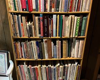 Five-tier bookshelf; hundreds of cookbooks to be sold.