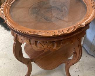 A gorgeous, very old round walnut or Maple occasional table with a glass top.