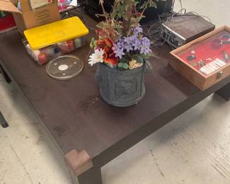 There is a beautiful square wooden table with a glass top for sale.