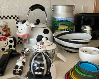 Black and white kitchen items....cow teapot, milk can filled with lollipops, M&M clown holder, cow ice cream scoop