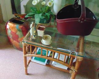 Rattan side table with glass top, books, fake plant, leather basket and vase (items sold separately).