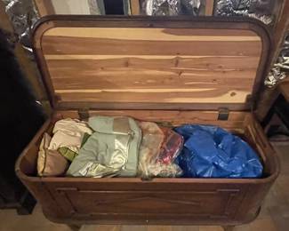 Hope chest with assorted blankets.