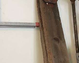 Antique cast iron school bell with yoke and wooden post.