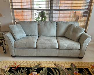  2 matching 3 seat sofas in pale pastel color