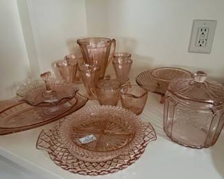 Lots of pink depression glass. Complete lemonade set with pitcher and 6 glasses in poinsettia pattern.