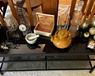 A beautiful black glass topped shelving unit willed with collectible smalls! 