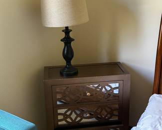 A very unique mirrored dresser with lamp.