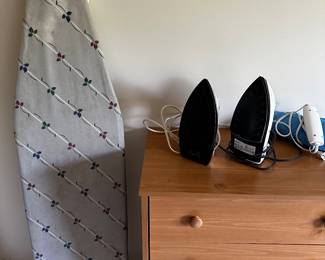 Tow irons and an ironing board. And another sm. dresser.