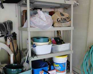 Plastic shelving unit, outdoor chair cushions, cleaning supplies, and car washing supplies, and looks like a very shy set of golf clubs in the back
