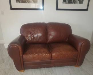 This leather love seat is at another location. Picture is true.