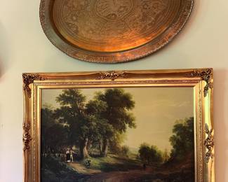 Huge vintage brass charger over a large vintage decorative picture