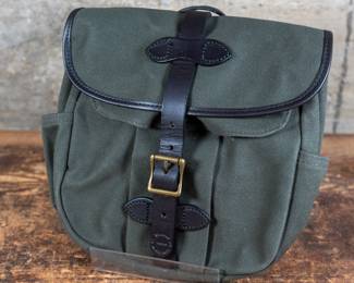 A Filson Small Rugged Twill Field Bag in Otter Green. Water-Resistant Rugged Twill with back and side open stow pockets. Expandable snap-flap pocket on front. Adjustable 40-48" leather shoulder strap. New condition.
