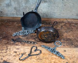 Pair of Griswold No. 3 pans, an iron heart hook/hanger and some decorative pieces.
