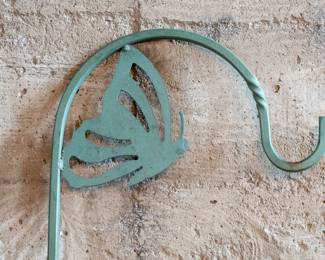 Three outdoor lawn shepherd hooks. Two painted green with a garden design, and one black with double-sided hooks. Largest green hook dimensions included.
