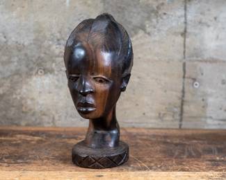 A bust of an African girl made of Ebony wood, originating from Sub-Saharan Africa.
