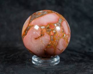 A pink King Cobra Jasper sphere, originating from India. Comes on a clear plastic base.
