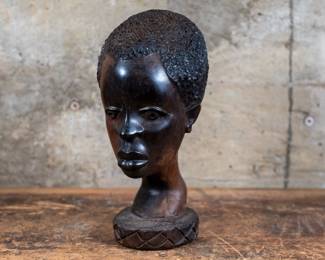 A bust of an African boy carved out of Ebony wood, originating from Sub-Saharan Africa.
