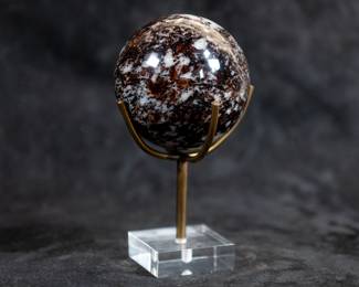 A sphere carved out of Almandine Garnet. This piece comes on a custom made brass stand with a clear plastic base.
