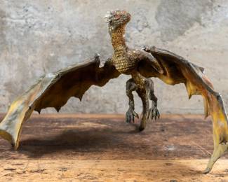 A custom painted plastic sculpture of a flying dragon.
