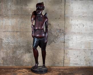 A wood carved statue of an African hunter carrying a snake. Originating from the Congo.
