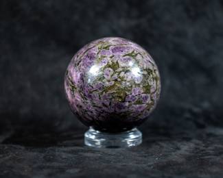 A Eudialite with Astrophyllite sphere originating from Russia. Comes on a clear plastic stand.

