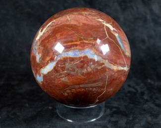 A large sphere made out of Red Ocean Jasper. Originating from Madagascar. Comes on a clear plastic base.

