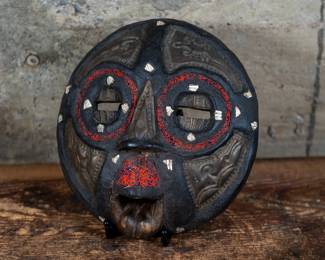 An Ashanti Baluba Moon Mask embedded with rings of red and black beads and shells. Originating from the Ashanti people of Ghana, Africa.
