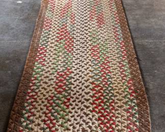 A long hand-braided multi-colored runner rug in farmhouse style.
