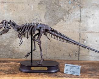 A 1/20 scale model of a Tyrannosaurus Rex skeleton. This model has excellent detail and comes on a solid black base. In addition, this comes with a metal informational sign about Tyrannosaurus Rex that can be displayed next to the piece, as well as a paper printout with information about the model and species.
