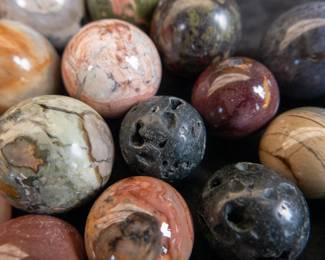 An assortment of spheres from a variety of minerals: Ukelite, Goldstone, Rose Quartz, Crystal, Lava Rock, Tiger's Eye, and Hematite Jasper. Largest sphere dimensions are included.
