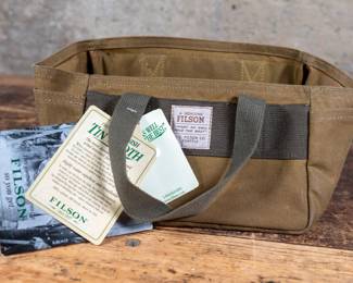 A Filson Tin Cloth Shot Shell Bag, Style #1012. 100% cotton tin cloth with oil finish. Two side pockets, and room for up to four boxes of shells. New Condition.
