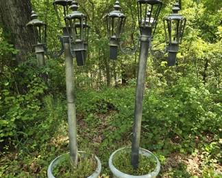 Pair of plastic planters with metal tiki torch
