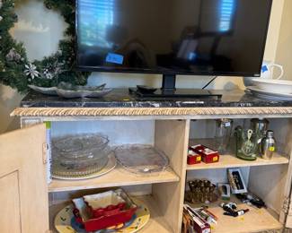large credenza with gemstone countertop, Christmas wreath, flat screen TV, martini mixer, glassware & wine bottle openers. 