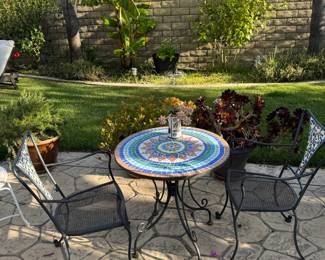 mosaic garden table with two iron chairs.