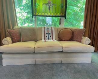 Cream colored sofa, Decorative pillows, Vintage stained glass window