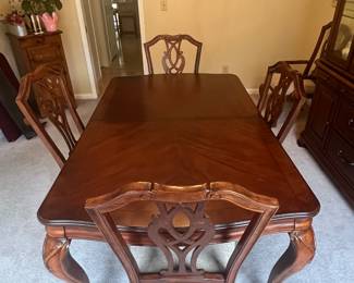Dining Room Table and Chairs, beautiful detail.  Has two leaves and 6 chairs.  4 are standard chairs and 2 are captain chairs.  Custom matts for table protection are also included