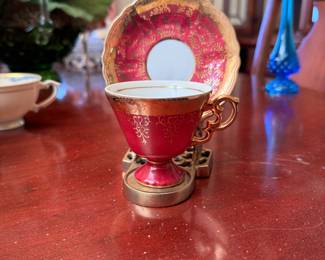 Royal Vienna red demitasse with gold decoration on an ornamental brass display