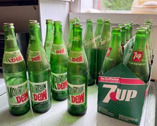 Group of vintage Mountain Dew, 7-up, and Sprite green bottles