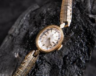 14kt gold-filled Omega ladies watch. Band is from Hong Kong. Unknown service history, but is in working condition. Current band will fit a 6'' wrist.