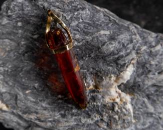 18kt gold pendant wrapped around Red Zincite. Total approx. weight is 8.68 grams and measures 2'' long. Includes original purchase receipt from Crystalarium in West Hollywood, California.