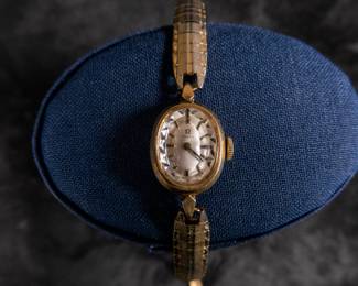 14kt gold-filled Omega ladies watch. Band is from Hong Kong. Unknown service history, but is in working condition. Current band will fit a 6'' wrist.