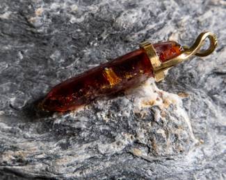 18kt gold pendant wrapped around Red Zincite. Total approx. weight is 8.68 grams and measures 2'' long. Includes original purchase receipt from Crystalarium in West Hollywood, California.