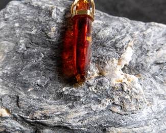 18kt gold pendant wrapped around Red Zincite. Total approx. weight is 8.68 grams and measures 2'' long. Includes original purchase receipt from Crystalarium in West Hollywood, California.