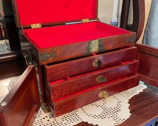 Oriental jewelry box of rosewood and brass with red silk interior. Comes with original brass padlock. 