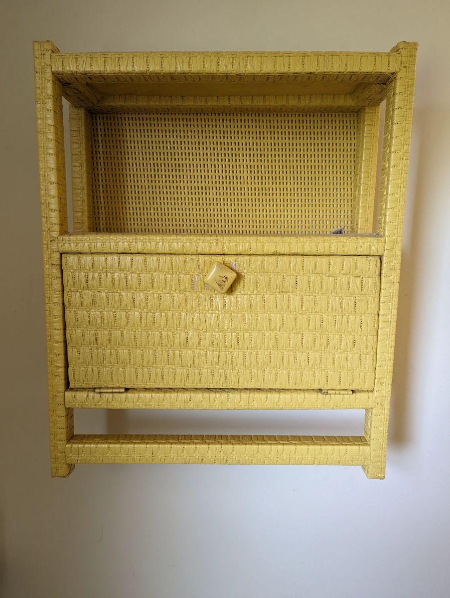 Vintage yellow wicker wall shelf/cabinet with one door and 2 shelves and one towel bar