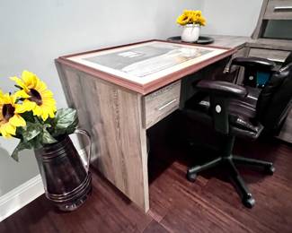 Desk with chair, faux sunflowers in vases.