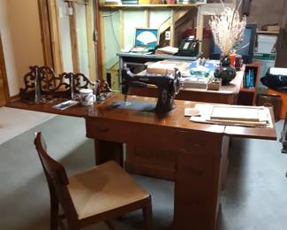 This is a White brand sewing machine with cabinet and chair in the basement. 